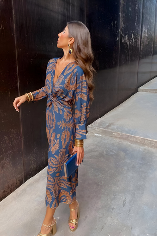 Robe midi bleue à encolure V, nœud torsadé au devant, motif floral doré.