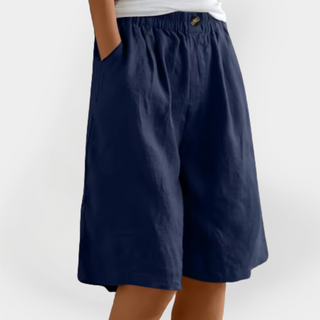 Short en lin bleu marine, taille élastique, poches latérales, bouton à l’avant.