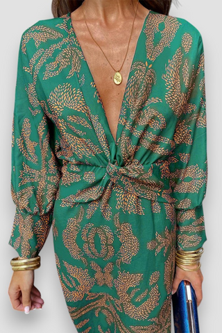 Robe midi verte avec nœud torsadé devant et motif floral doré, manches longues.