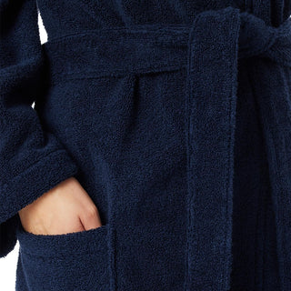 Tissu éponge bleu marine texturé sur peignoir à capuche, détail de couture près de la ceinture.