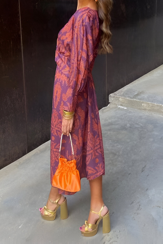 Robe midi violette à motif floral, encolure V, nœud torsadé au buste, manches longues.