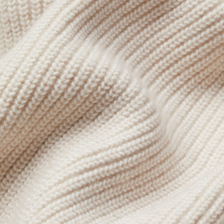 Détail du tricot du cardigan en laine crème, maille fine côtelée et surface texturée