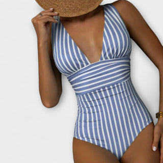 Maillot de bain une pièce bleu à rayures, décolleté V plongeant et forme ajustée.