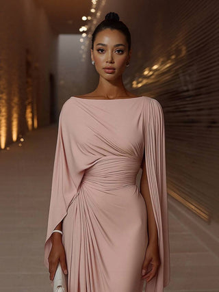 Robe maxi rose pâle à taille drapée, manches cape fluides, encolure ronde, coupe longue.