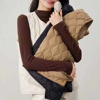 Gilet matelassé sans manches beige, col rond, boutons, détails matelassés en relief.
