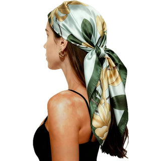 Foulard carré en satin vert clair et fleurs stylisées, noué, brillance satinée.