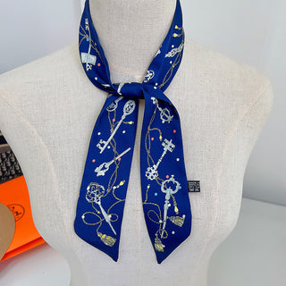Foulard étroit bleu roi à motifs de clés et chaînes, noué au cou