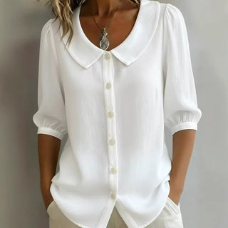 Blouse en lin blanche, col claudine, manches 3/4 bouffantes, boutonnée au devant.