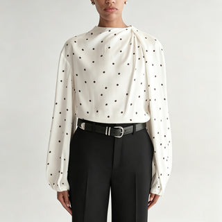Blouse blanche à pois noirs, col drapé et manches bouffantes, en satin léger