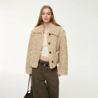 Veste courte en fausse fourrure bouclée beige, col chemise, boutonnage simple.