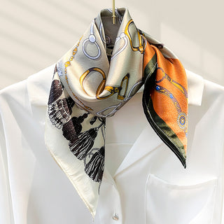 Foulard carré en soie beige et orange, motifs décoratifs et fleurs, noué au cou.