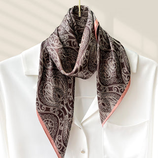 Carré de soie brun foncé à motifs cachemire, liseré rose, à nouer au cou.