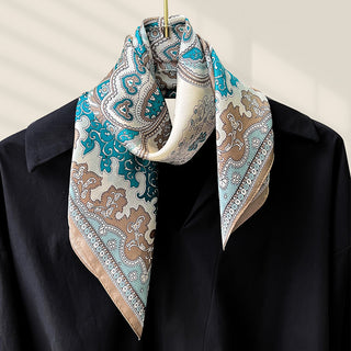 Foulard carré en soie turquoise et beige à motifs cachemire, noué au cou.