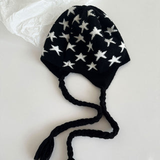 Bonnet à oreillettes noir à étoiles blanches, cordons tressés et pompons