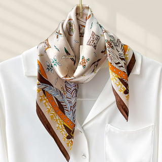 Foulard carré en soie crème, motifs oiseaux et plumes, bords marron et orange.