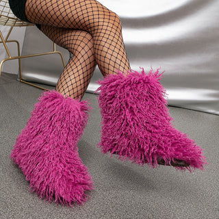 Bottes moumoute mi-mollet en fausse fourrure violette, bout pointu et tige duveteuse.