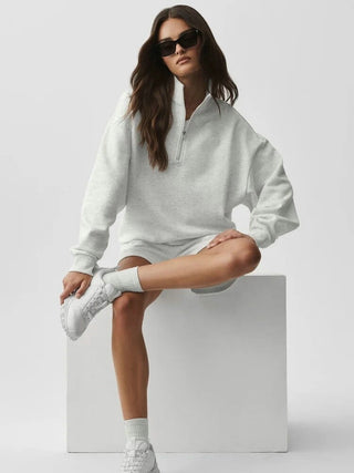 Sweat demi-zip gris clair avec col montant, porté, manches longues et coupe oversize.