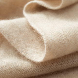 Écharpe triangle en cachemire beige, gros plan sur la texture maille et le bord