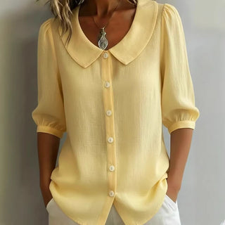 Blouse en lin jaune clair, col claudine, manches 3/4 bouffantes, boutonnée au devant.