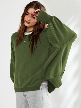 Sweat-shirt vert olive ample à manches longues et poignets couvrants, porté avec un jean