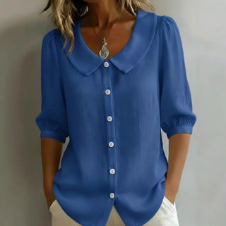 Blouse en lin bleue, col claudine, manches 3/4 bouffantes, boutonnée au devant.