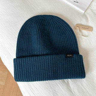Bonnet en laine bleu foncé, maille côtelée, revers large, étiquette noire