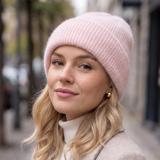 Bonnet ample en maille rose pâle, porté avec le revers replié