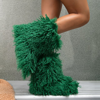 Bottes moumoute mi-mollet en fausse fourrure verte, tige très touffue et silhouette galbée.