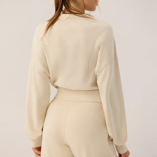 Veste zippée courte crème à col montant, coupe cintrée, manches ballon en jersey