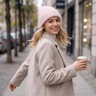 Bonnet ample rose pâle en maille côtelée, porté avec un revers