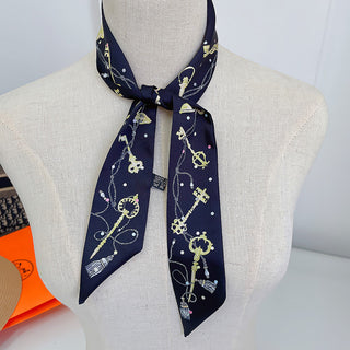 Foulard étroit bleu marine à motifs de clés dorées, noué au cou