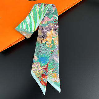 Foulard étroit vert d’eau à imprimé floral et zèbre, noué autour d’un sac