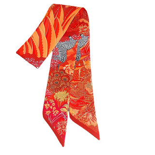 Foulard étroit rouge à imprimé floral et zèbre, noué autour d’un sac