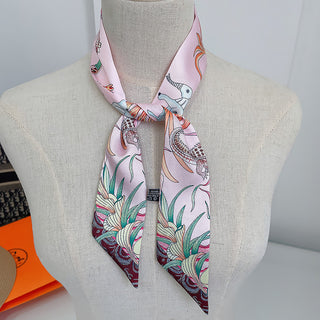 Foulard étroit rose pâle à motifs floraux et animaliers, noué autour du cou