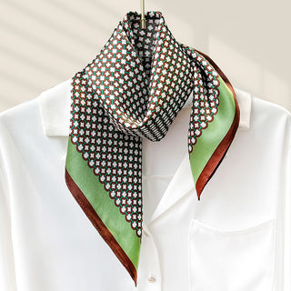Foulard carré en soie vert et bordeaux, motifs de chaînes, noué au cou.