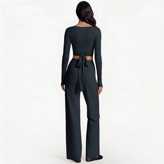 Ensemble yoga femme noir, vue de dos : haut manches longues et pantalon évasé noué