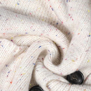 Détail cardigan femme en maille blanche texturée, bouton noir et fil multicolore.