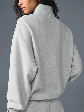 Sweat col montant gris clair, vue dos, manches longues amples et épaules tombantes.