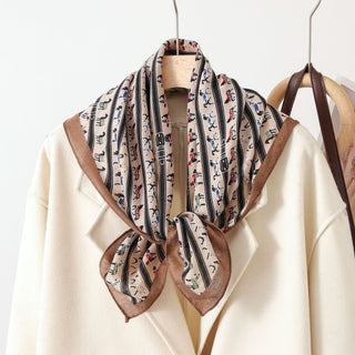 Foulard en soie imprimé chevaux, fond beige crème, liseré brun, noué.
