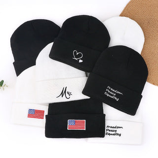 Ensemble de bonnets tricotés noir et blanc, motifs brodés et écussons