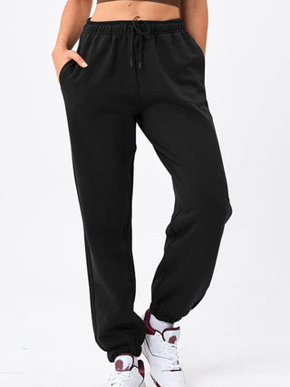 Pantalon de sport noir ample, cordon de serrage, ourlets resserrés