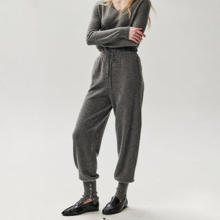 Pantalon de jogging en maille gris foncé, taille à cordon, chevilles boutonnées et côtelées.