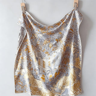 Foulard double face beige et gris imprimé jungle, drapé sur cintre.