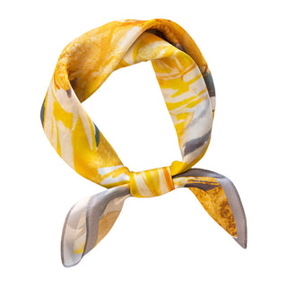Foulard en soie jaune à motif floral, nœud au cou, extrémités effilées