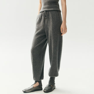 Pantalon de jogging en maille gris foncé, taille élastique à cordon, chevilles boutonnées.