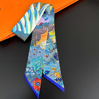 Foulard étroit bleu à imprimé floral et zèbre, noué autour d’un sac
