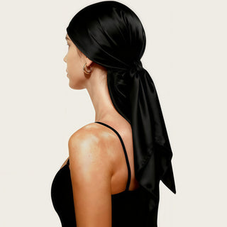 Foulard carré en satin noir, noué derrière la tête, aspect satiné lustré.