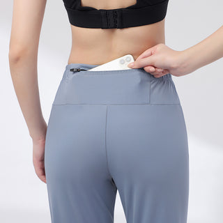Pantalon de sport bleu-gris vu de dos, avec poche arrière zippée à la taille