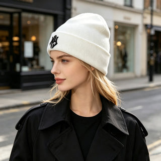 Bonnet en laine blanc côtelé à revers, broderie noire, vue de profil.