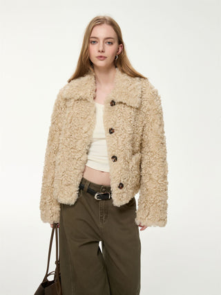 Veste courte beige en fausse fourrure bouclée, col chemise et boutons visibles.
